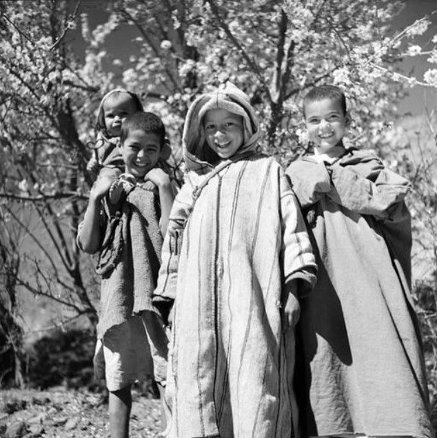 Haut Atlas: Jeunes Berbères de la région au sud de Marrakech, portant la djellaba. Le garçon au centre porte une djellaba de laine rayée et tissée sur le métier familial.